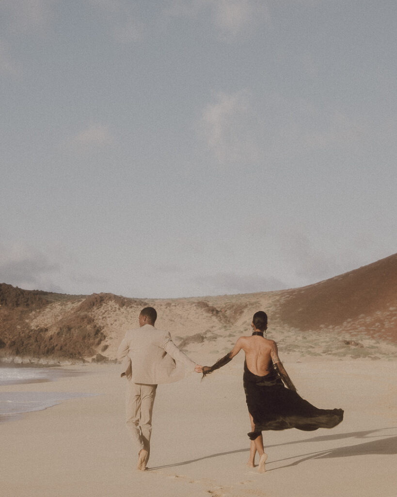 Newly married couple walk along one of the beautiful beach of Las Conchas.